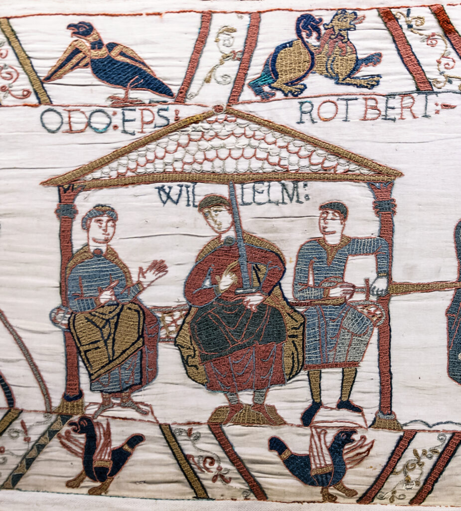 Bayeux tapestry exert William the Conqueror sits in between two knights at the Battle of Hastings. 