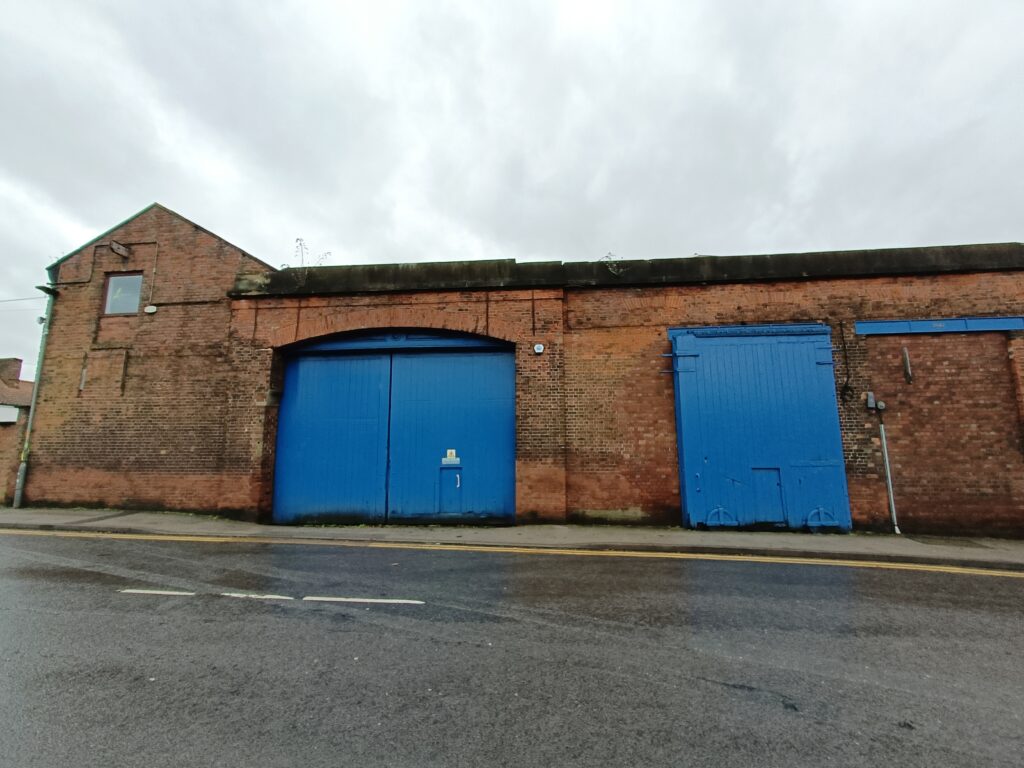 The original Selby station. Two large blue double doors in a brick warehouse building